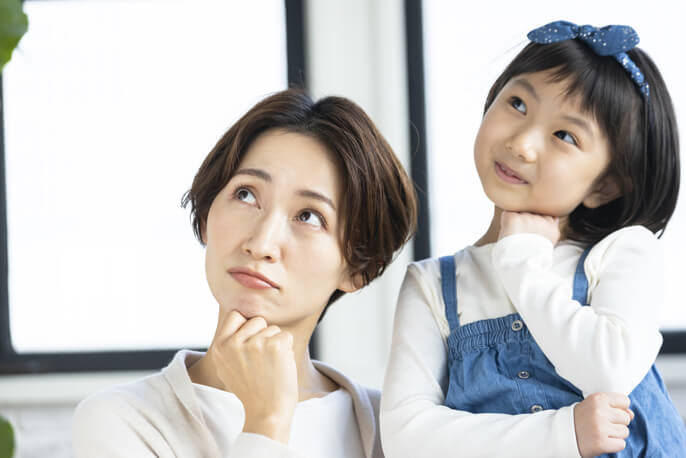 母親とともに首を傾げる女の子