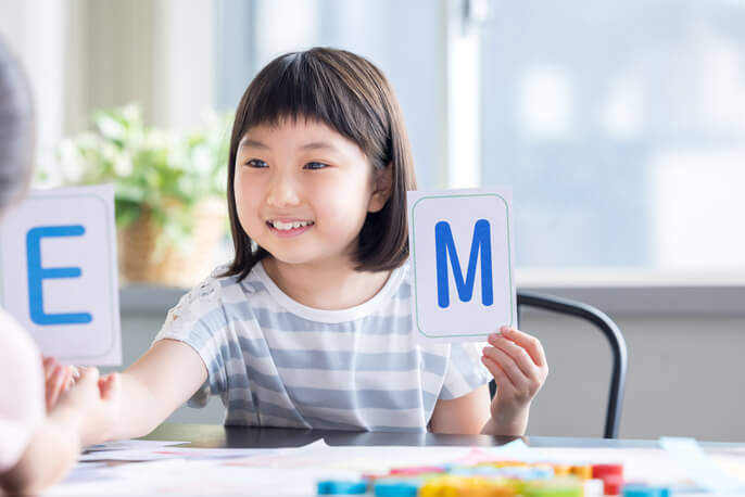 アルファベットのカードで英語学習をする女の子