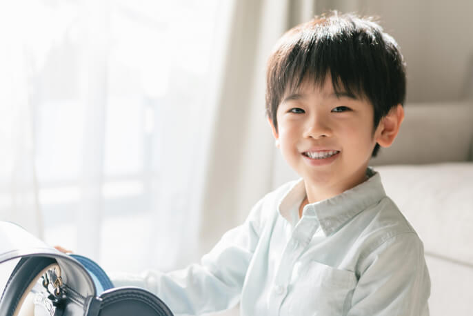 ランドセルを置き笑いかける男の子