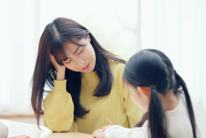 頭を抱える母親と女の子