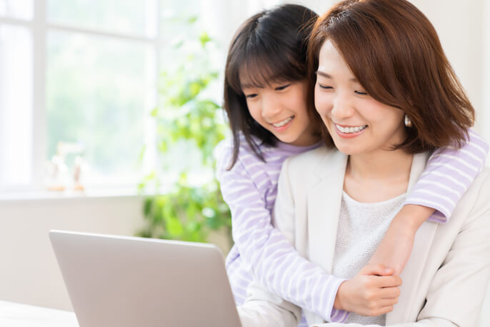 パソコンを見て微笑む母親と子供