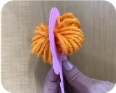 Put the yarn through the hole and cut.